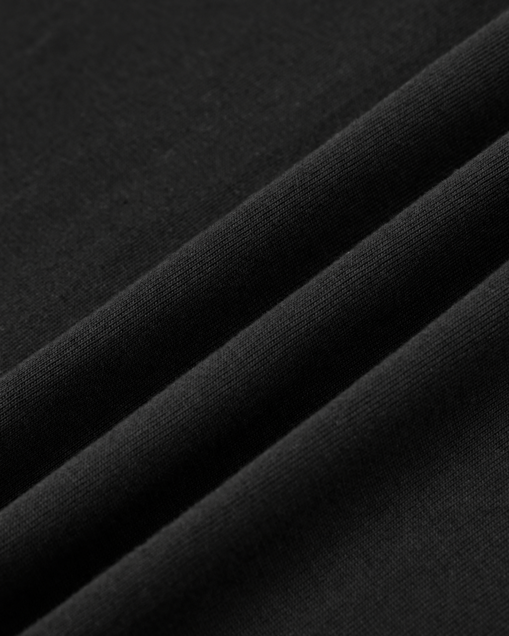 Texture du jersey de coton noir disposé en plis diagonaux