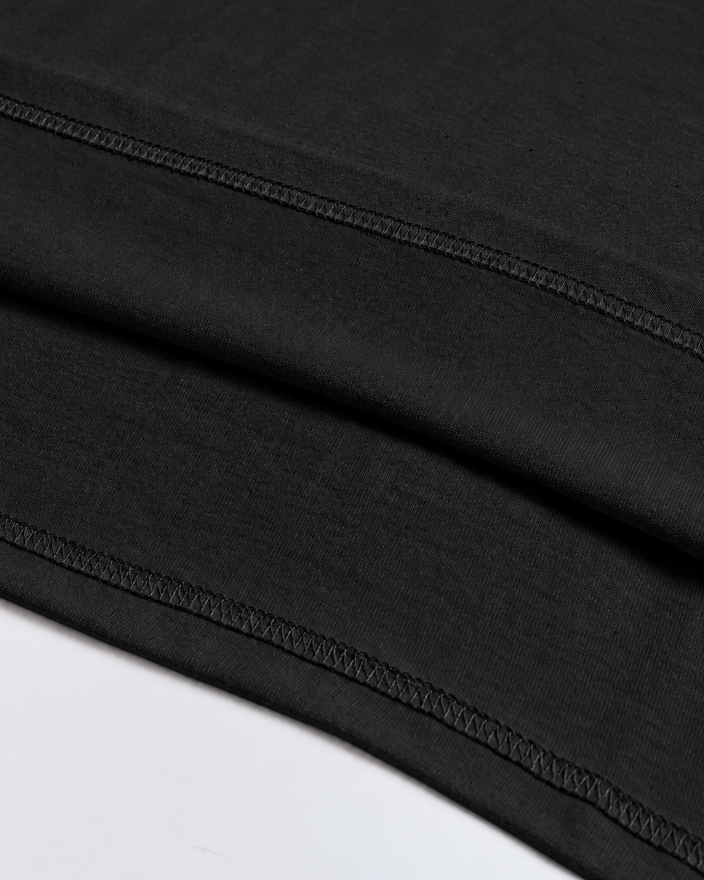 Close-up of the double-stitched hem on the black Belarté Six Seven T-shirt